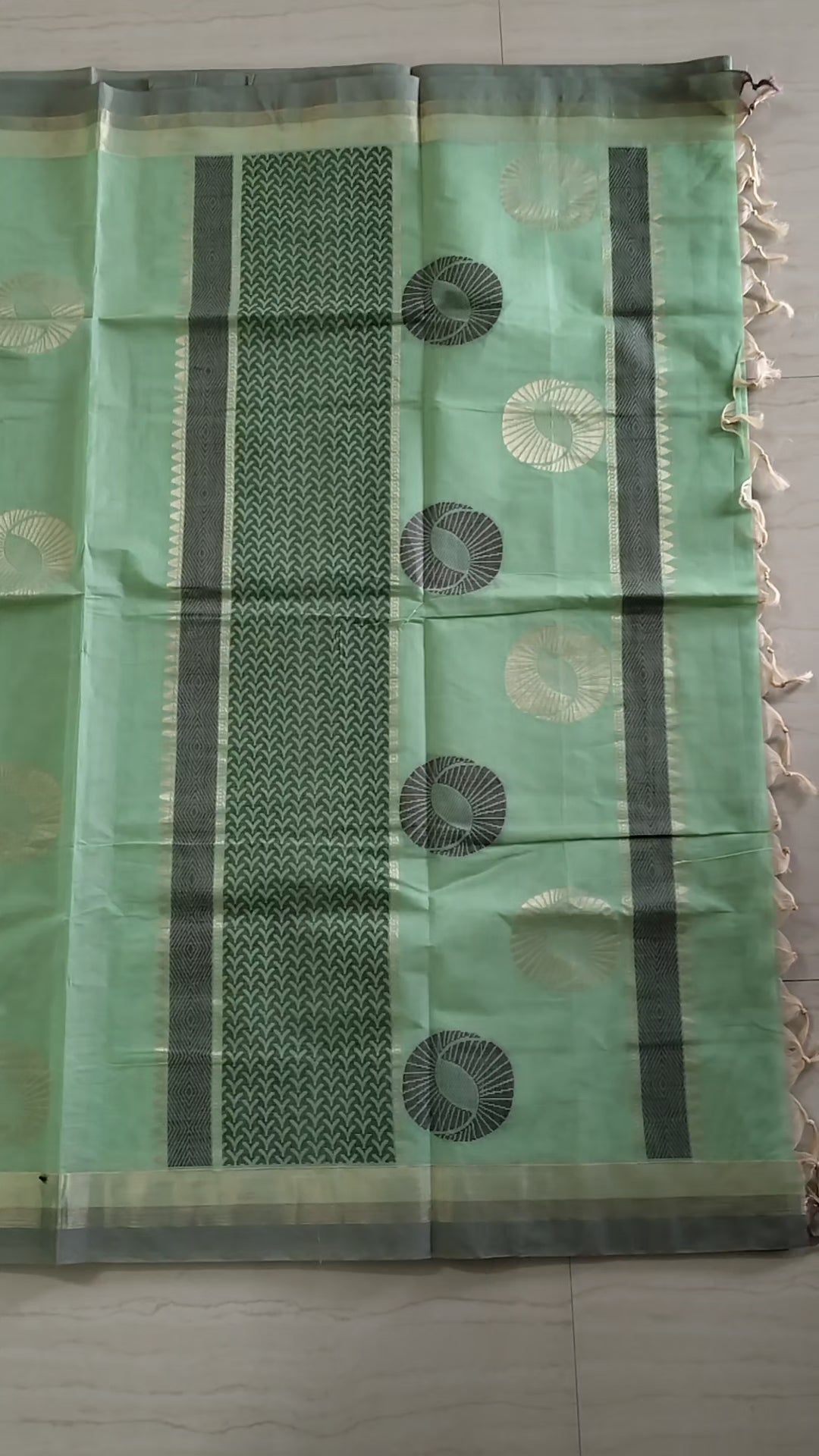 Pastel green cotton saree with alternate golden zari & black flower buttas