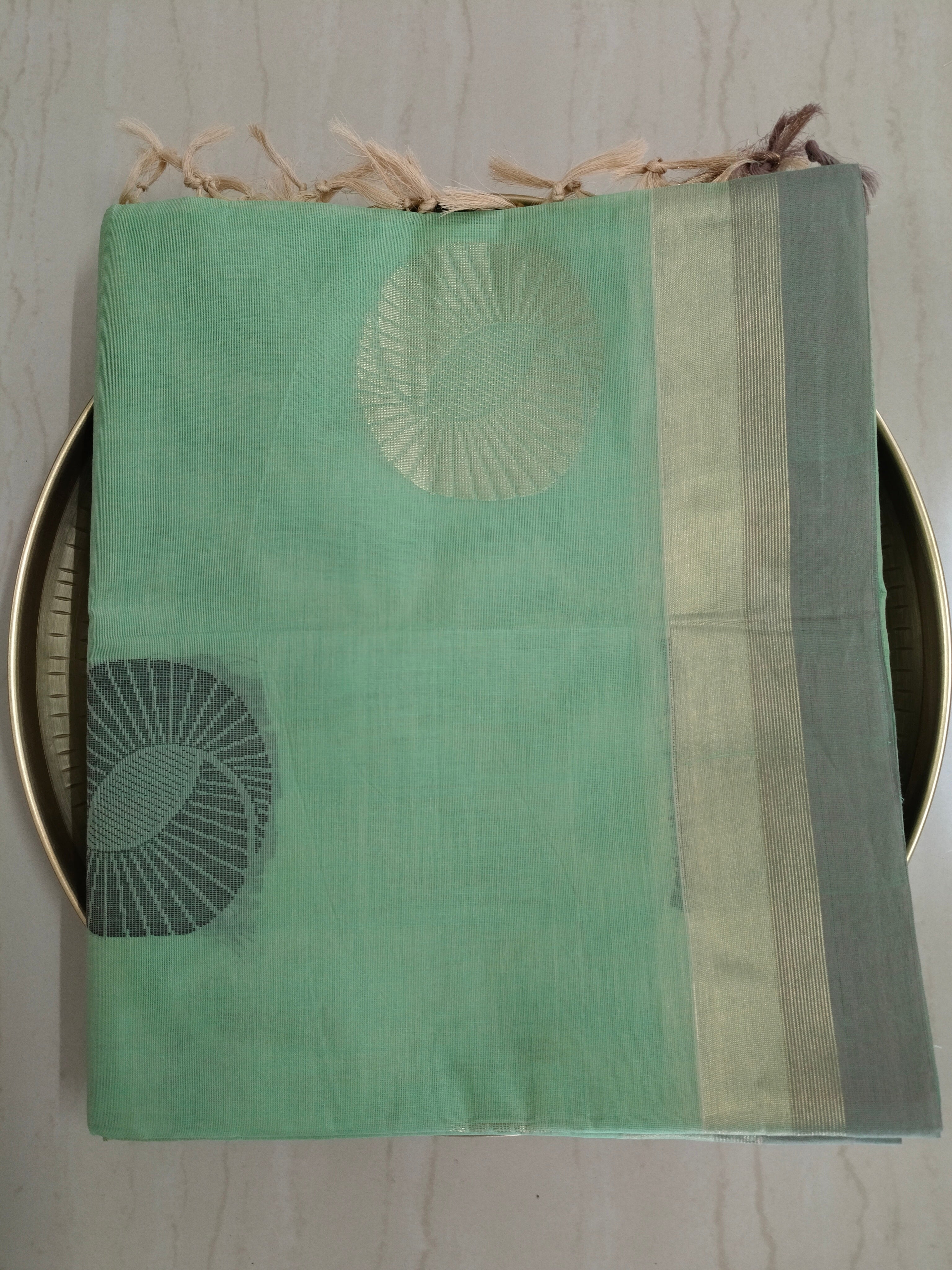 Pastel green cotton saree with alternate golden zari & black flower buttas