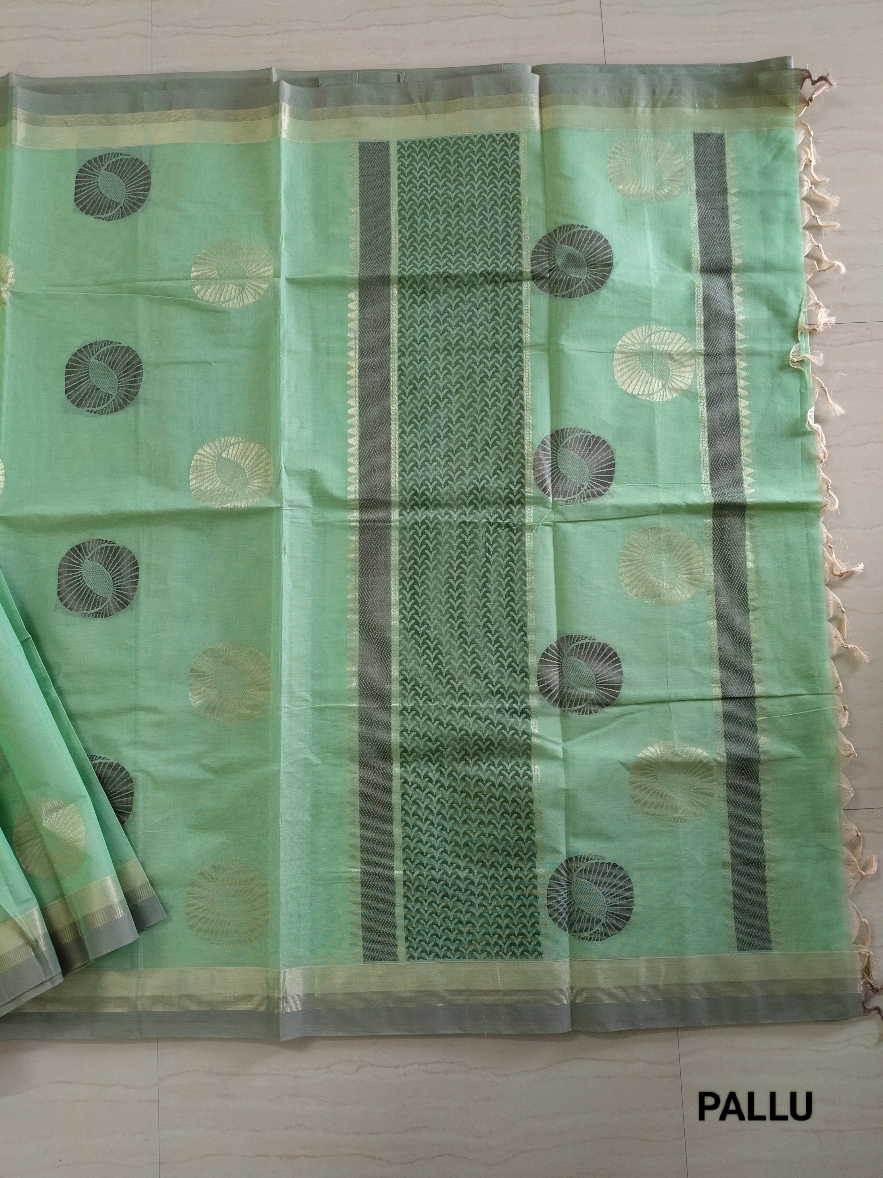 Pastel green cotton saree with alternate golden zari & black flower buttas
