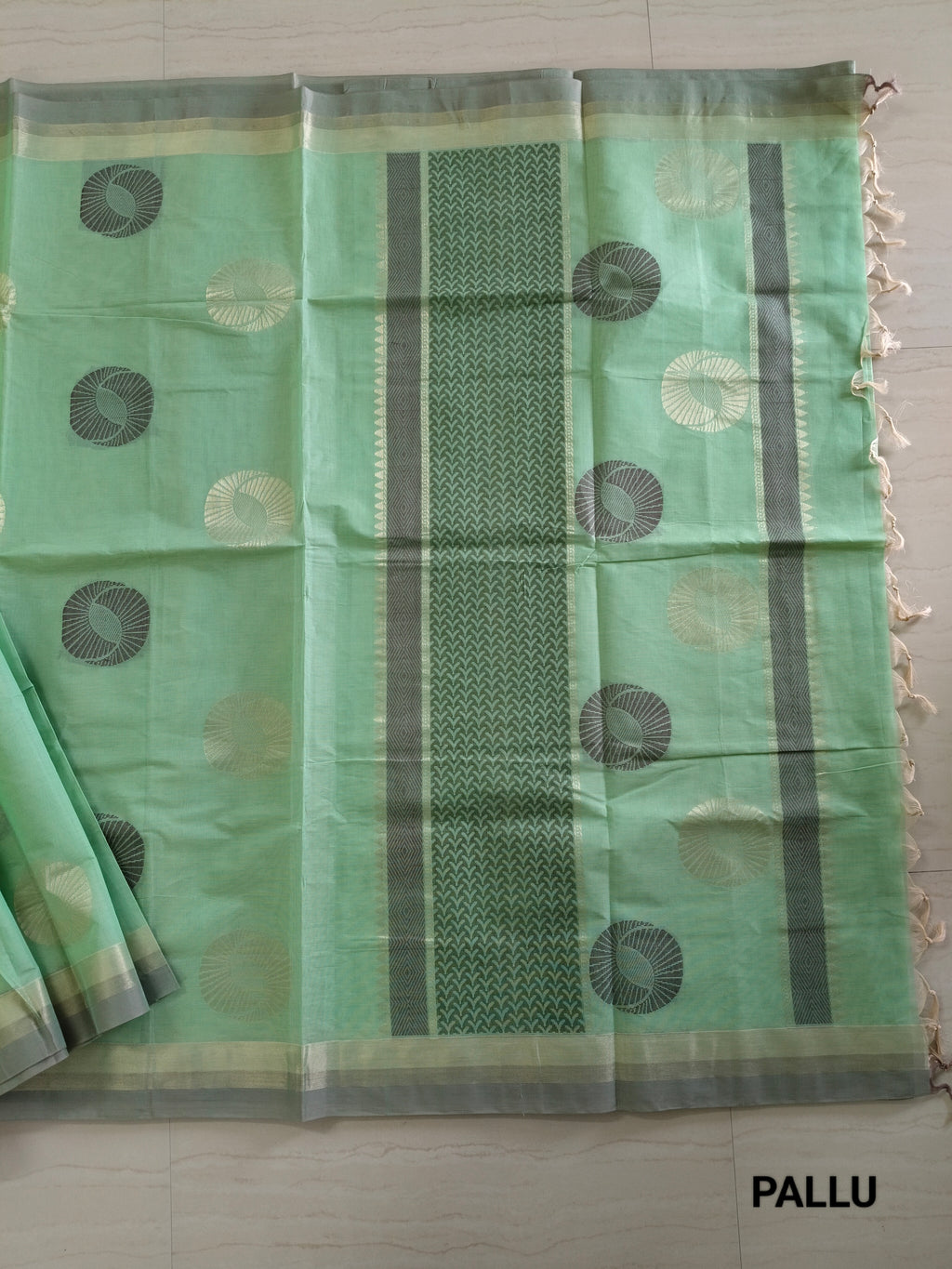 Pastel green cotton saree with alternate golden zari & black flower buttas