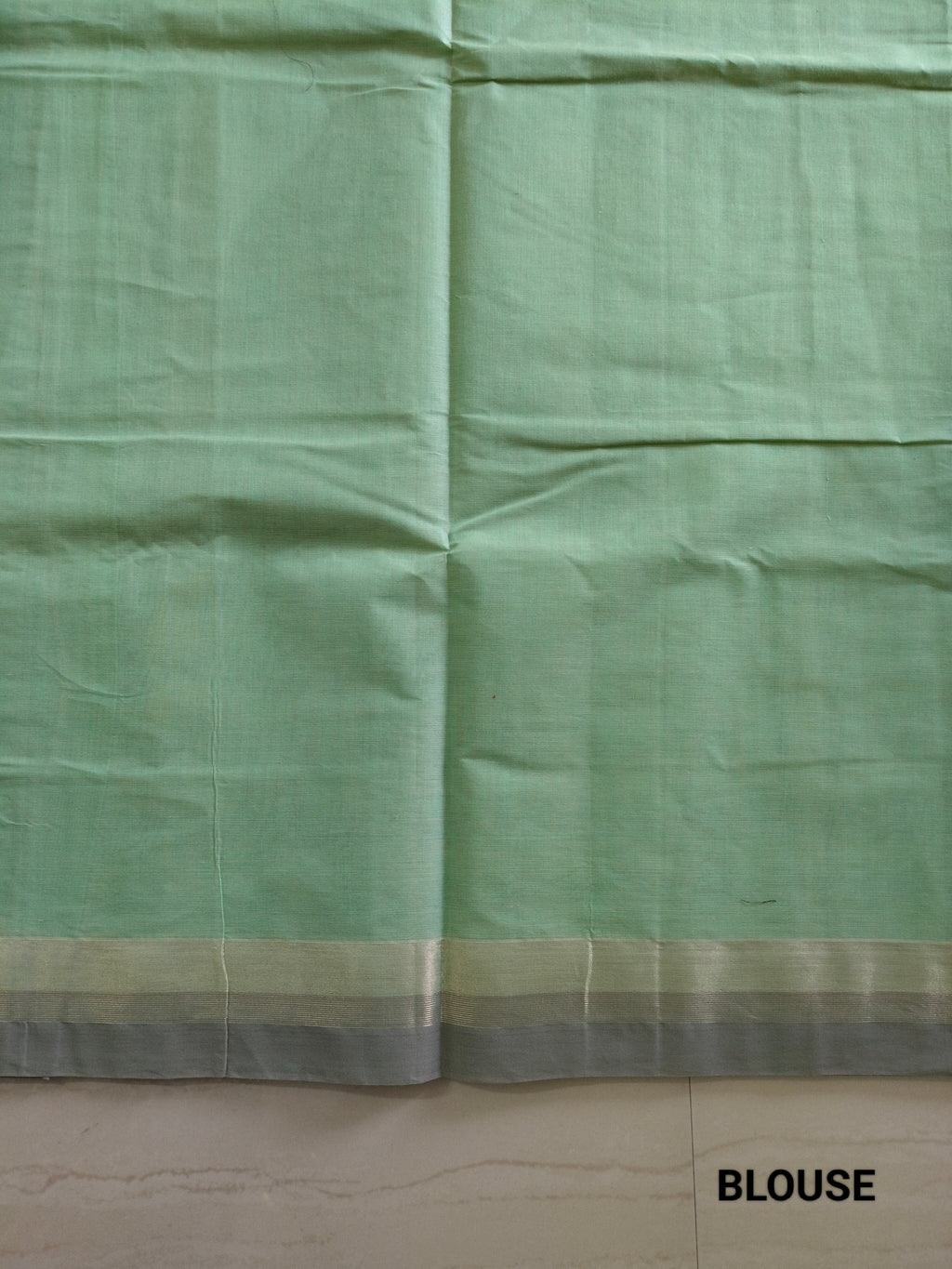 Pastel green cotton saree with alternate golden zari & black flower buttas