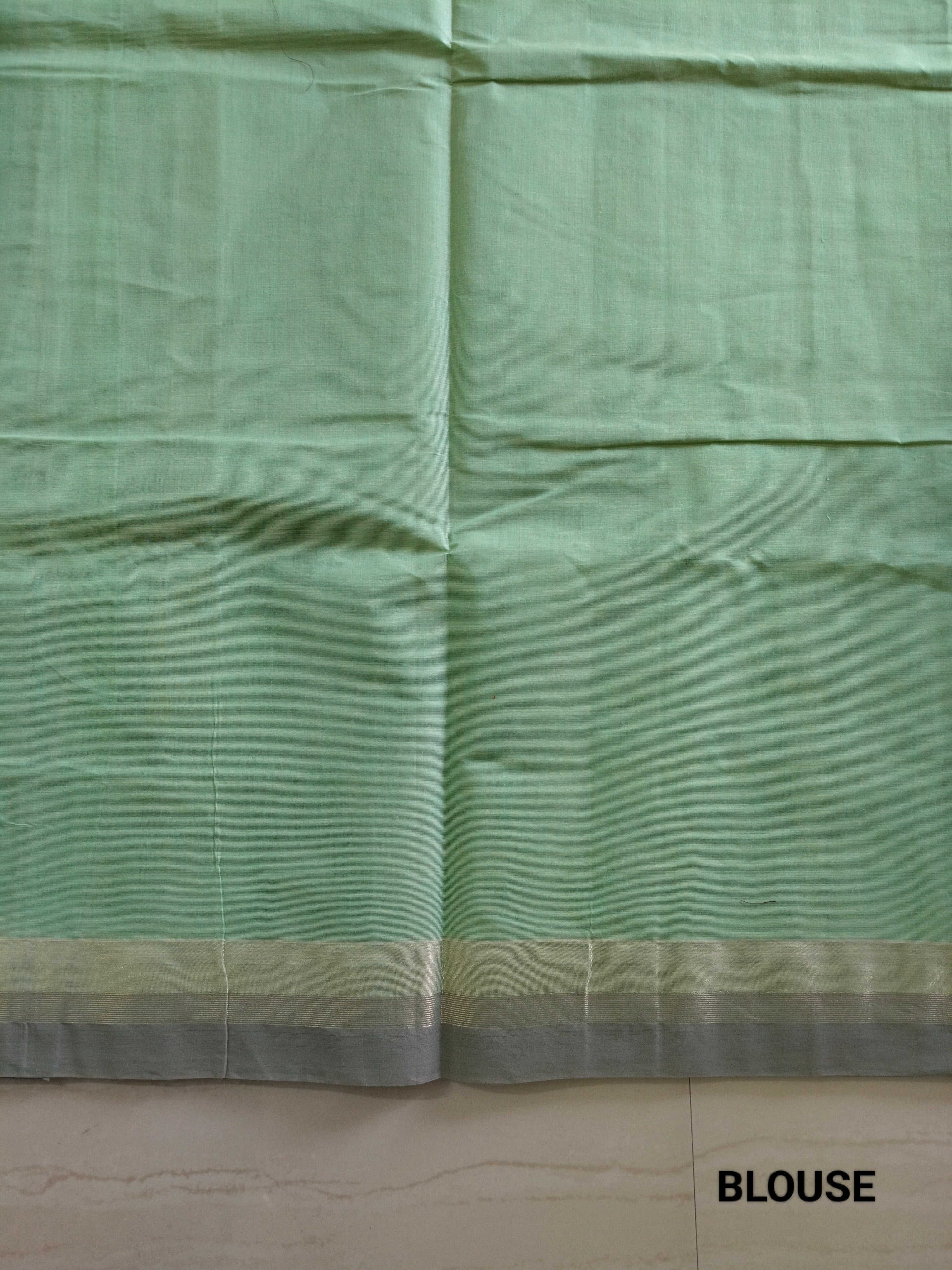 Pastel green cotton saree with alternate golden zari & black flower buttas